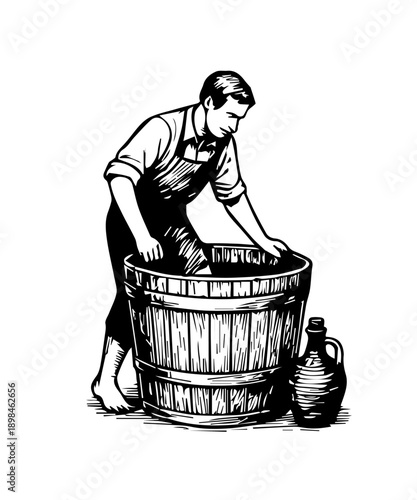 Winemaker crushing grapes for wine production in barrel