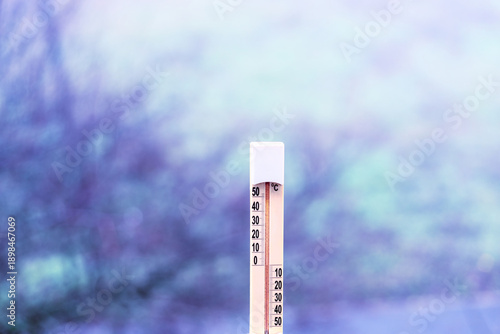 Εκτύπωση καμβά Outdoor thermometer against a background of green nature in the cold morning light with a blurred background, close-up