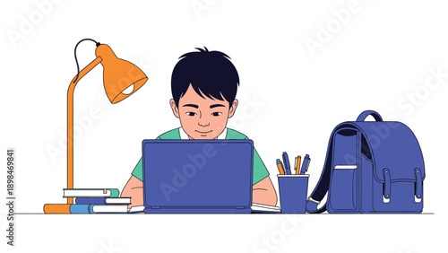 Focused young boy sits at his desk with a desk lamp and school supplies while using a laptop to study or do homework.