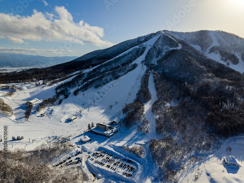 Sunny winter day overlooking ski runs and parking at Madarao Kogen