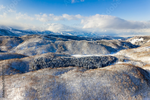Scenic panorama of the Japanese Alps region with snowy hills and clouds