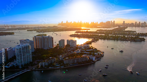 Miami islands and skyline at golden hour. Golden hour aerial view of Miami skyline with islands and calm bay waters.
