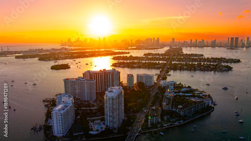 Miami coastal cityscape during sunset. Sunset aerial view of Miami coastal skyline with glowing city and water.