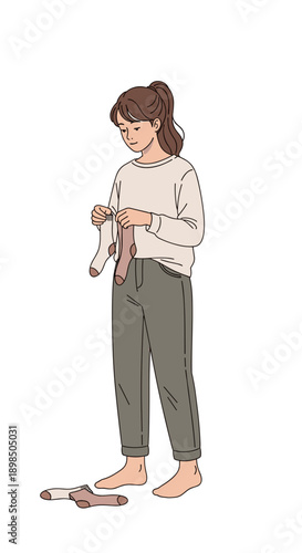  Woman sorting socks into pairs, laundry routine at home