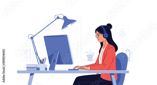 Female freelancer with glasses and headphones working on a desktop computer at her organized desk in a home office.