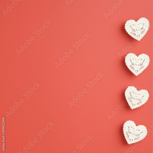 Four white lace hearts on a coral background.