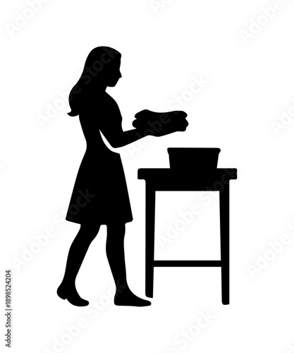 Woman silhouette folding laundry on table at home