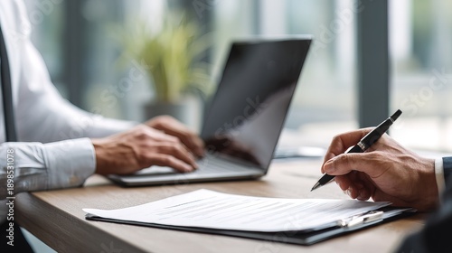 Professional hr manager engaged in typing notes on laptop in modern office setting with natural light focus on productivity and efficiency