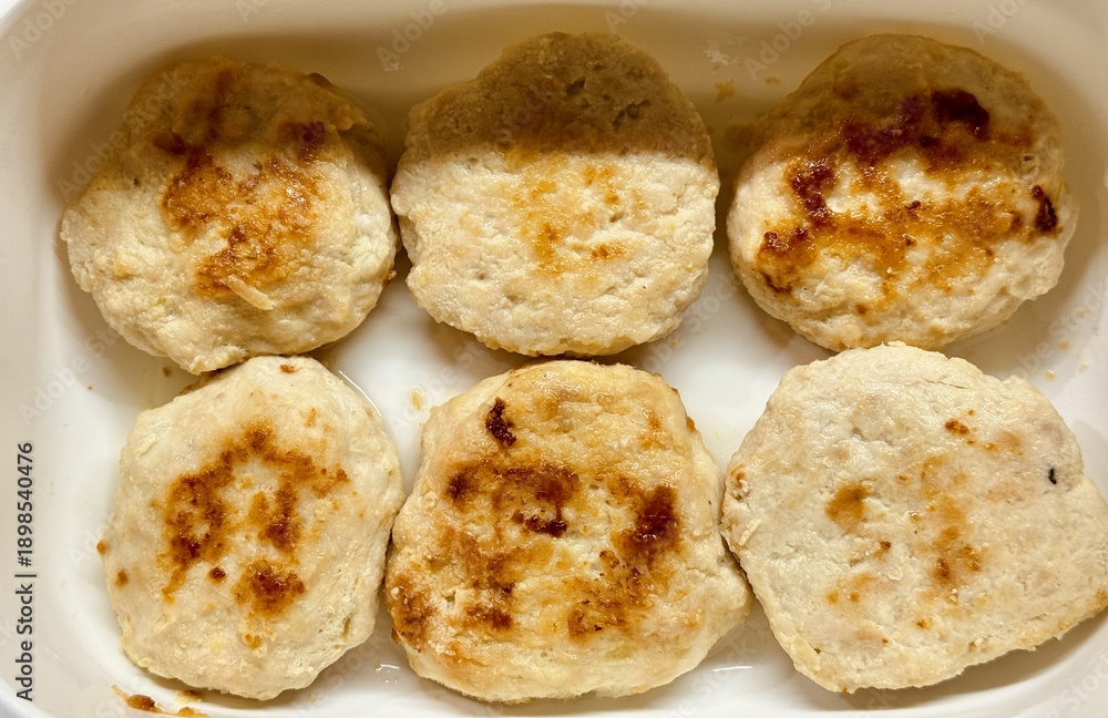 Fototapeta premium Fried Meat Patties. Homestyle Fried Meat Served On Tray. Meal Featuring Homemade Fried Meat In White Dish. Rustic Homemade Meat Cutlets With Golden Crust Prepared For Family Lunch