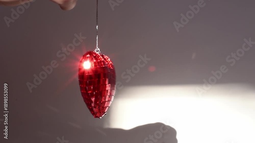 Glass red heart is spinning in a circular motion on white background, concept of love,emotions, romance, tenderness and balance . St.Valentines day background, horizontal video