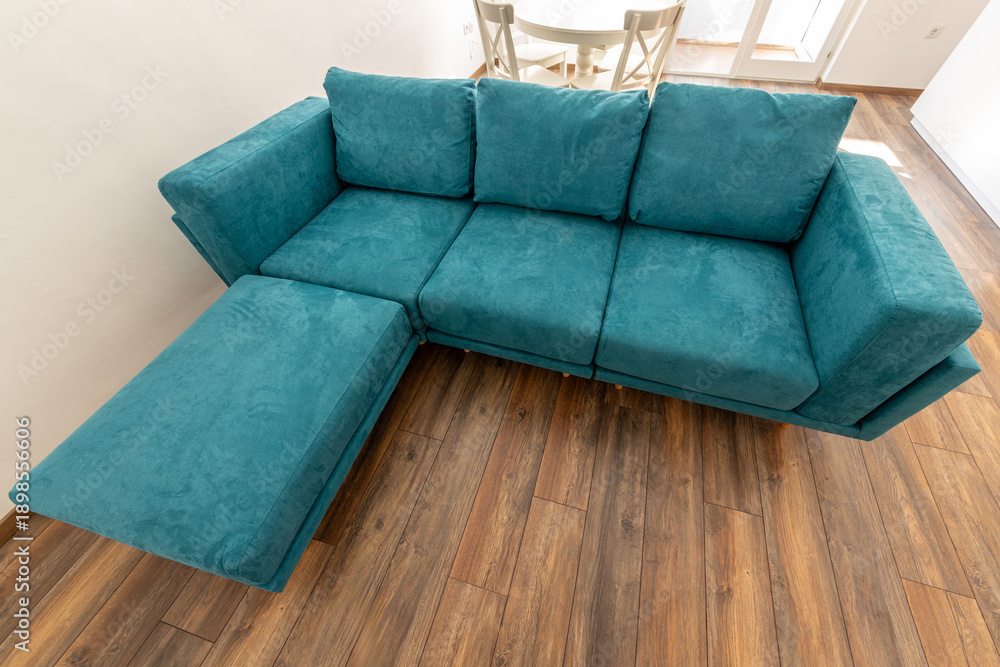 custom made wallpaper toronto digitalModern teal sectional sofa in a bright living room. Stylish L-shaped couch on a dark wood laminate floor. Contemporary home furniture and interior design concept.