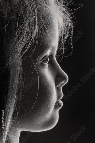 Wallpaper Mural Beautiful black and white profile portrait of a little girl's face, isolated on a dark background. A touching and dramatic image of childhood innocence, contemplation, and dreams. Torontodigital.ca