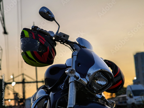 Wallpaper Mural Motorcycle with Helmet Hanging on Handlebar at Sunset, Urban Street Scene with Dramatic Evening Light, Symbol of Freedom, Adventure, and Modern City Lifestyle Torontodigital.ca