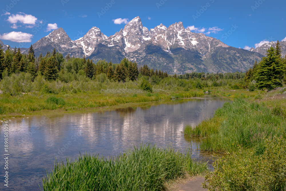 Fototapeta premium The sharpest peaks of the Teton range reflected in the waters of a river