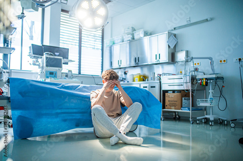 Foto Worried teenage patient sitting alone on hospital floor, struggling with mental health issues