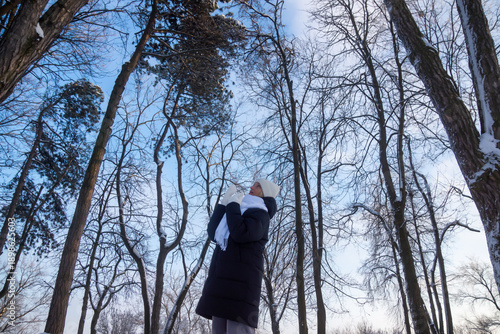 Young beautiful girl walking in a winter park.