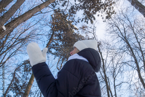 Young beautiful girl walking in a winter park.