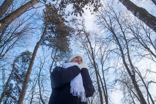 Young beautiful girl walking in a winter park.