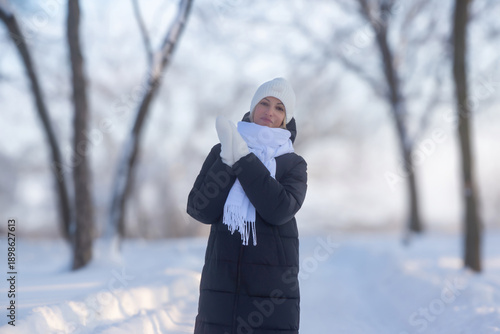 Young beautiful girl walking in a winter park.