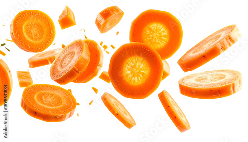 Sliced orange carrot pieces in mid-air against a black background