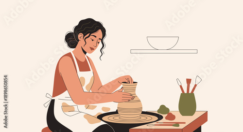 Young woman shaping clay vase while working at pottery wheel  