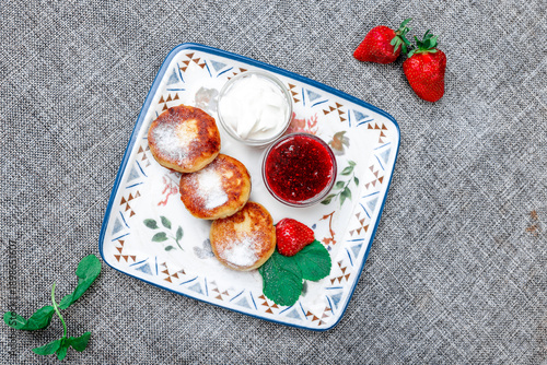Traditional Russian Syrniki (Cottage Cheese Pancakes) with Sour Cream and Raspberry Jam. view from the to