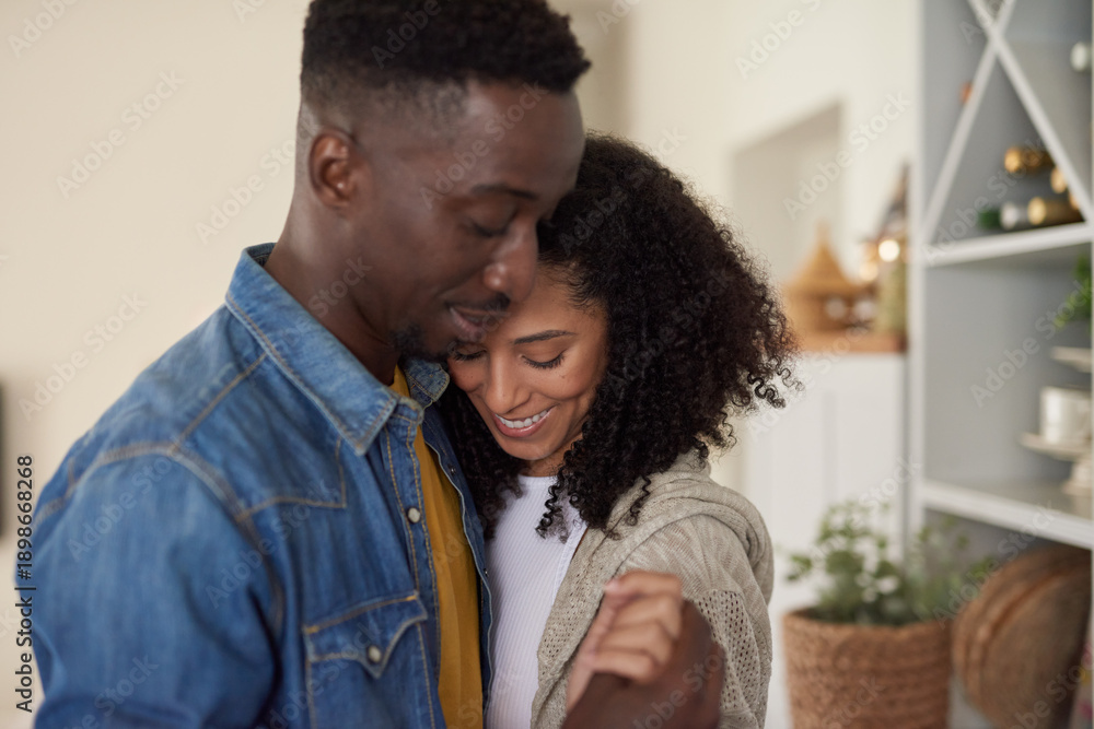Obraz premium Loving young multiracial couple smiling and dancing in their kitchen