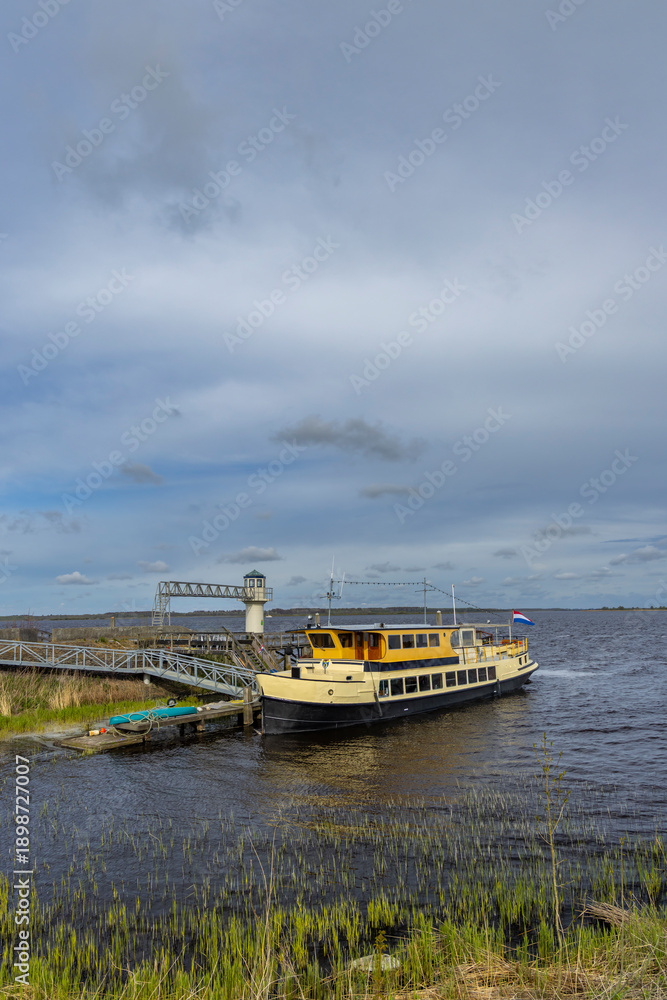 Fototapeta premium Ferry boat docking at a pier on a lake