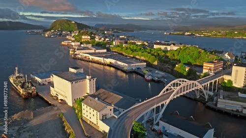 Wallpaper Mural Aerial drone view of Alesund, Norway from Aksla Viewpoint showing industrial buildings, bridge access, and shoreline during golden hour sunset.Over the harbou, roads, and rooftops, norwegian. Torontodigital.ca