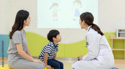 Pediatrician doctor examines young boy with mother present in bright clinic using projection for speech therapy assessment and communication skills development