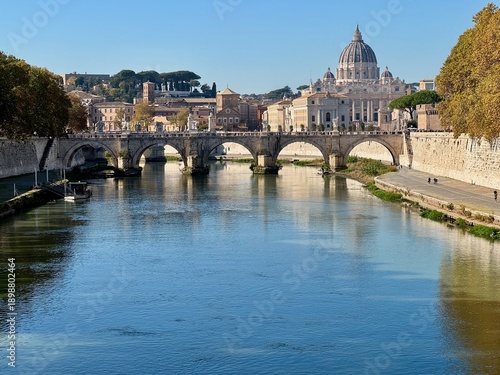 Photography Panoramic view of Saint Peter Basilica dome and Ponte Sant Angelo bridge over Tiber River with reflections in Rome Italy on sunny autumn day