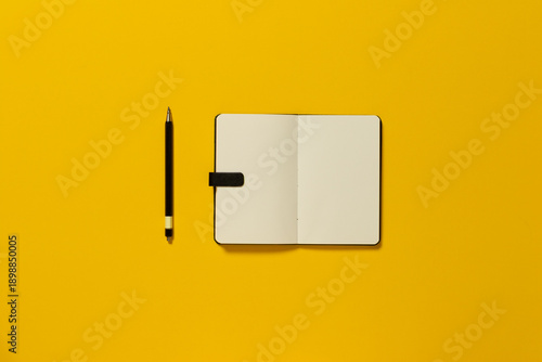Overhead view of s notepad and pen on colourful background