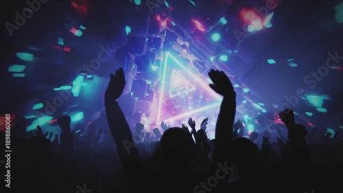 A vibrant crowd enjoys a concert with a neon light display, creating an energetic atmosphere