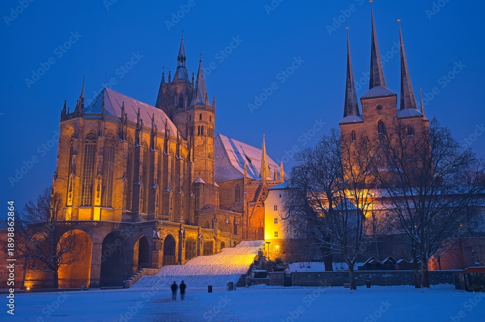 Obraz premium cathedral square in Erfurt with view to snow covered cathedral and church Severi at a winter day in the blue hour