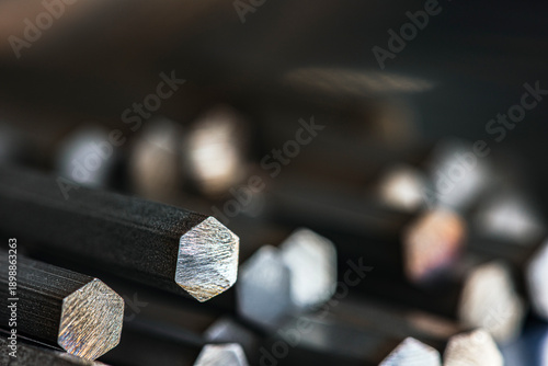Close up view of hexagonal stainless steel bars showing cross sections. Industrial metallurgical products used in manufacturing, engineering, and metal processing applications.