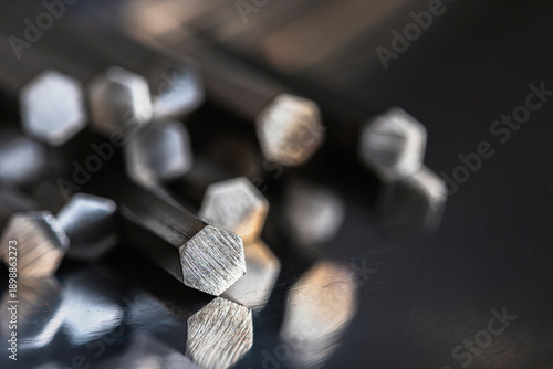 Close up view of hexagonal stainless steel bars showing cross sections. Industrial metallurgical products used in manufacturing, engineering, and metal processing applications.