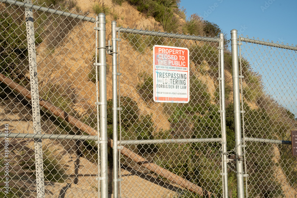 Fototapeta premium Chain link fence with 'Property Closed to the Public' sign and 'No Trespassing' warning