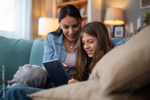 Mother and daughter bonding over technology at home