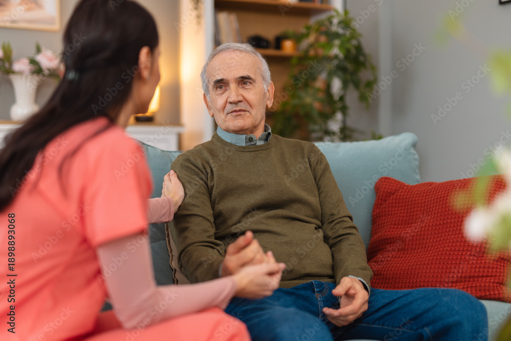 Obraz premium Caregiver supporting senior man receiving home care