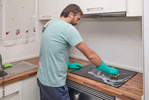 Εκτύπωση καμβά Wiping electric cooktop with sponge and cloth during home cleaning