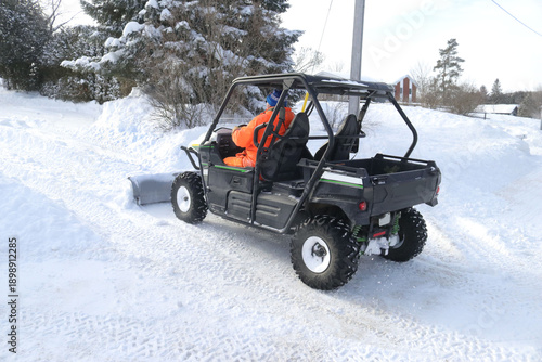 People moving snow after huge snowfall wather event, with snowblower and ATV snowplow