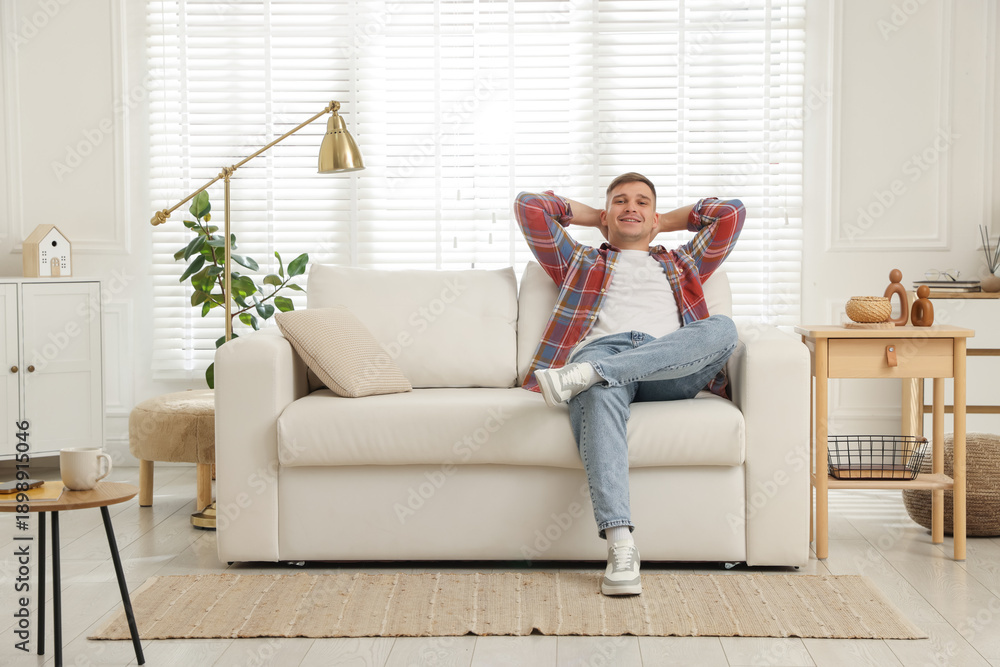 Fototapeta premium Young man relaxing on sofa at home