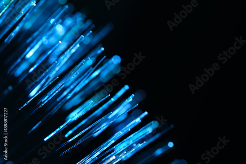 Blue optical fiber strands for telecommunication technology. Abstract digital background with bokeh. 5G network and cloud computing visualization.