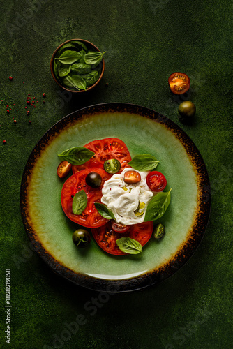 Neoclassical caprese salad serving. Italian food. Salad. Caprese lies on a green plate, top view. Flat lay