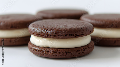 Delicious homemade chocolate sandwich cookies with a creamy white filling, beautifully arranged on a clean white surface, perfect for a sweet treat or dessert