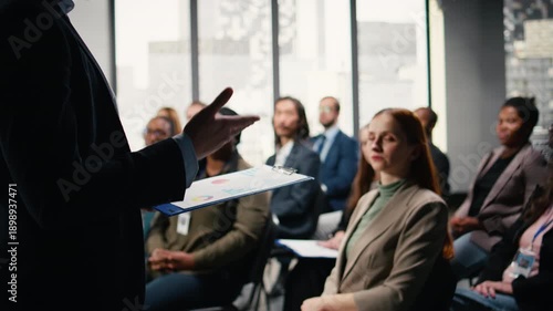 Multiethnic people asking questions and raising hand during discussion, engaging in debate and listening to convention speech. Diverse group of white collar workers attend event. Camera A.