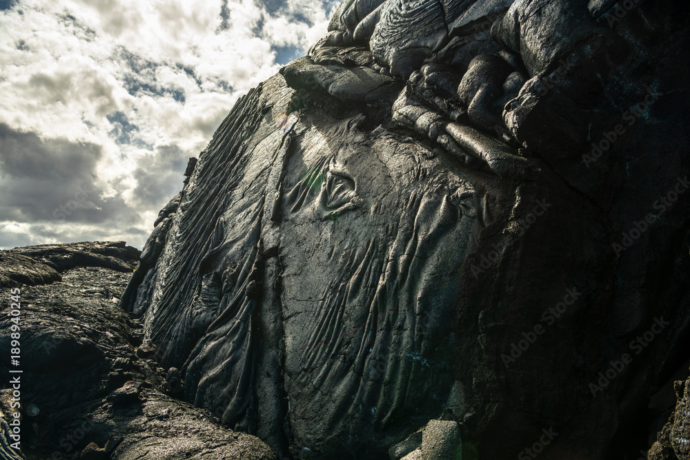 Fototapeta premium Hardened lava field with detailed volcanic textures on the Big Island of Hawaii, formed by ancient lava flows under natural daylight.