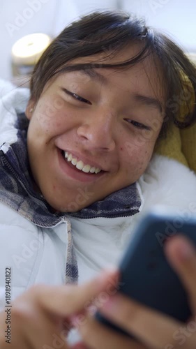 Young smiling woman using smartphone on social media