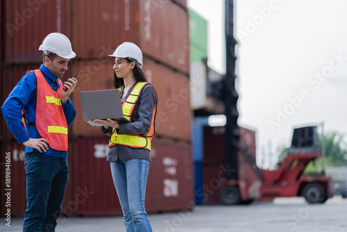 Two logistics workers man and woman discuss operations at a busy shipping container yard. successful coordination in freight, transportation, and supply chain operations