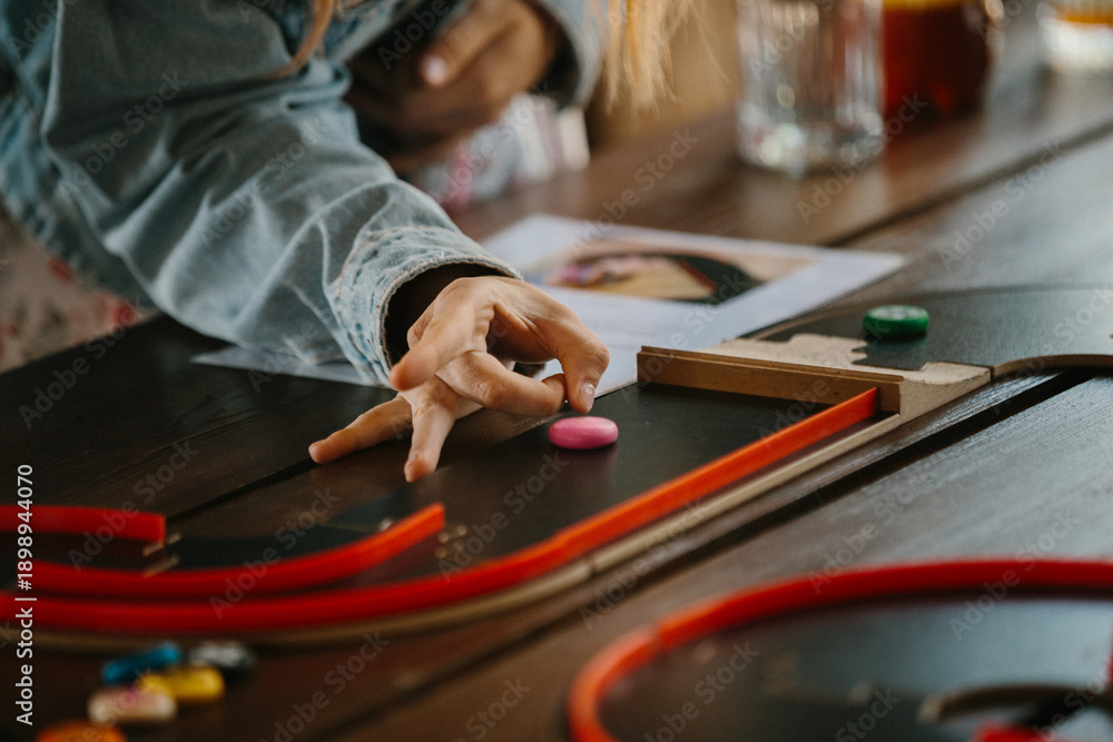 Obraz premium Hand playing tabletop game with colorful pieces
